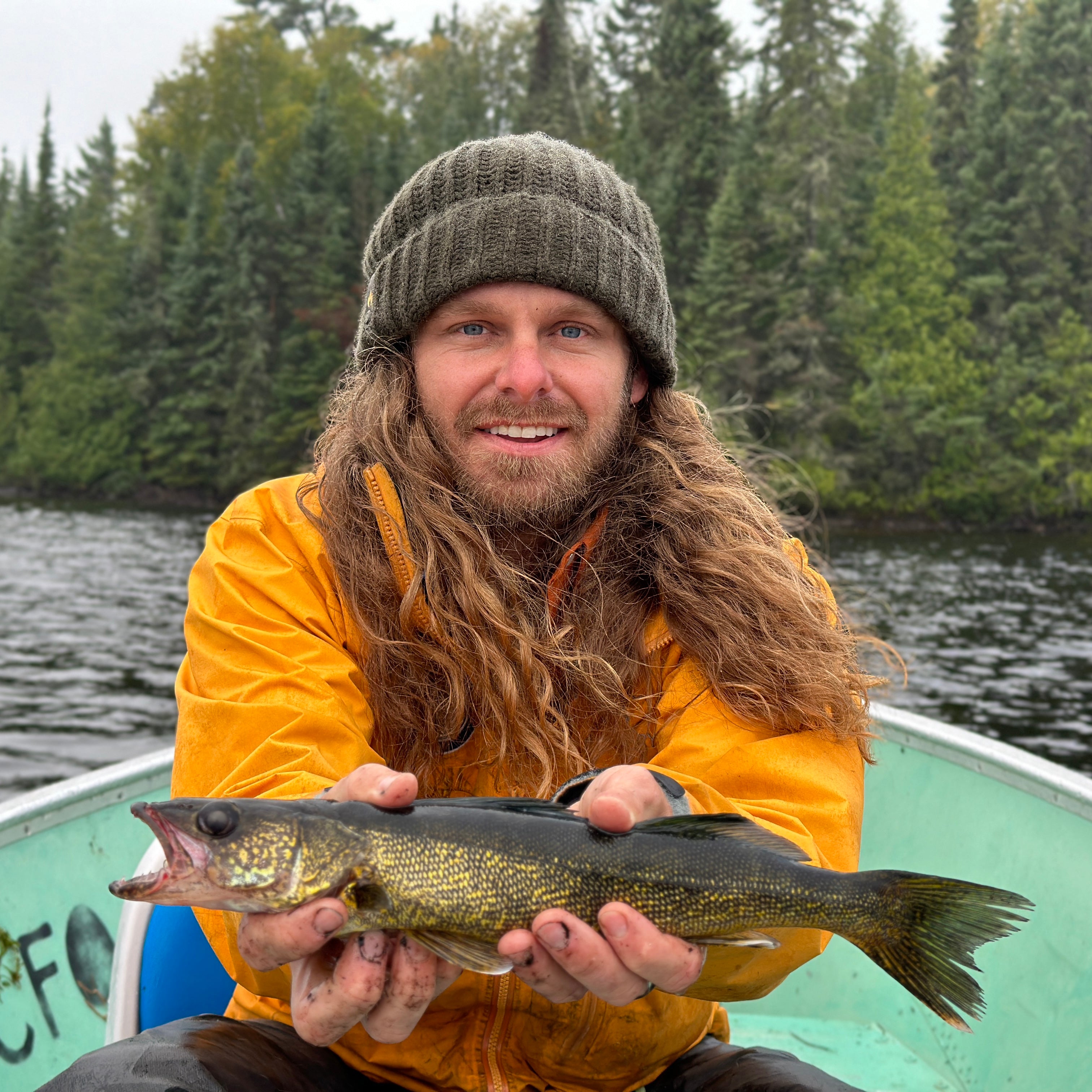 Wazoo Cache Beanie in the outdoors with fish in hand