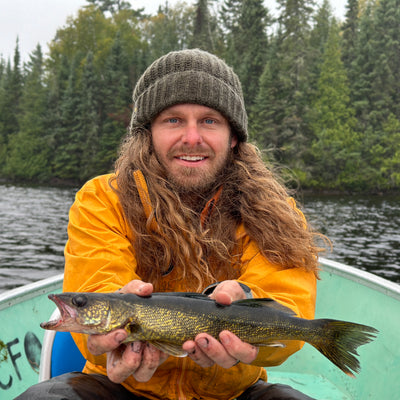 Wazoo Cache Beanie in the outdoors with fish in hand