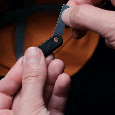 Gif of a keychain being put in the pockets on the brim of a hat