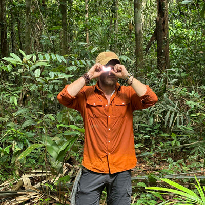 Man demonstrating signal mirror in the jungle