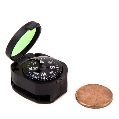 black clamshell container with compass and reflective glow light on the inside of lid compared to the size of a penny that is similar in size
