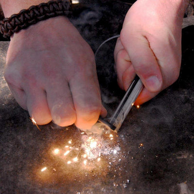 using the folding ceramic knife and a ferro rod to create large sparks to start a fire