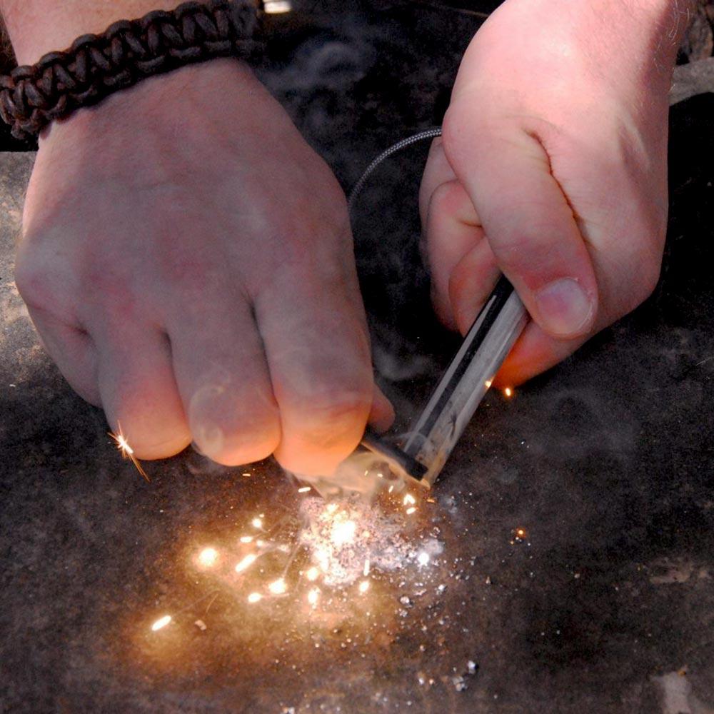 using the folding ceramic knife and a ferro rod to create large sparks to start a fire