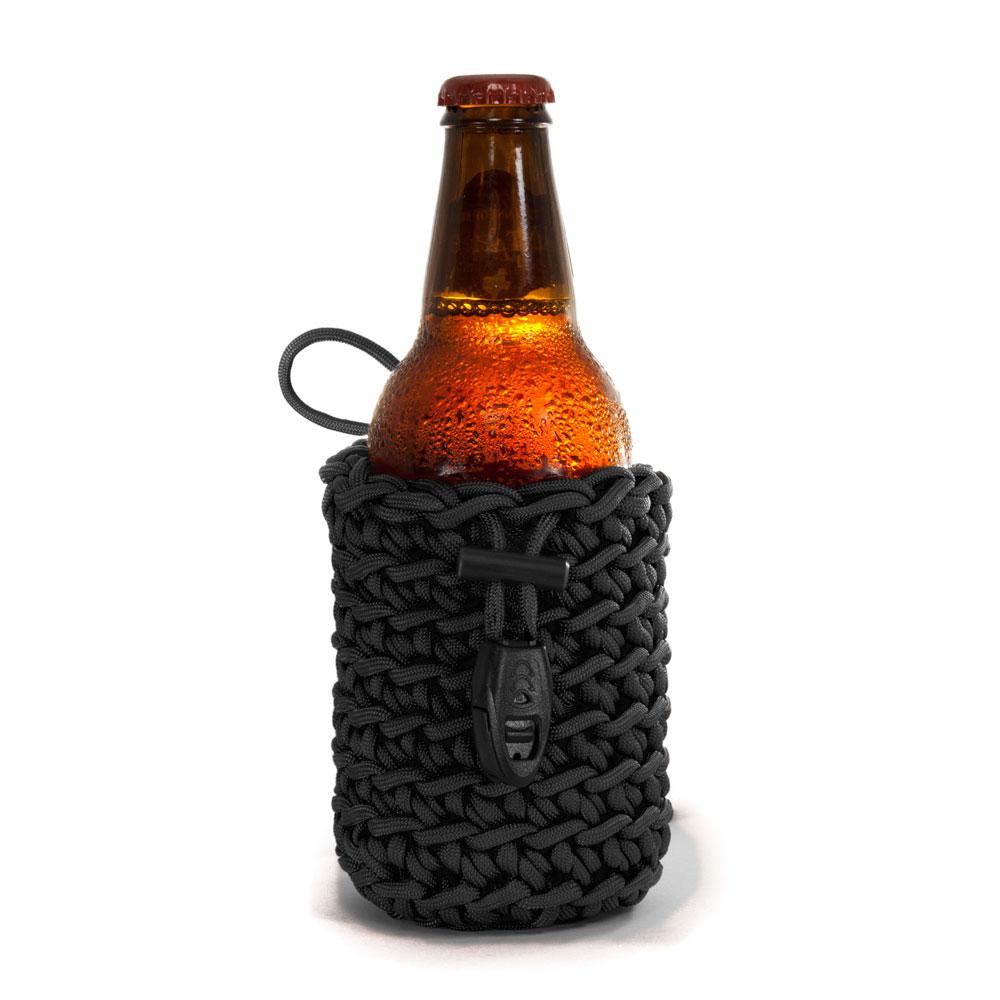 Small black paracord beverage skin pouch with beer bottle inside that comes with attached whistle ferro rod and ceramic scraper