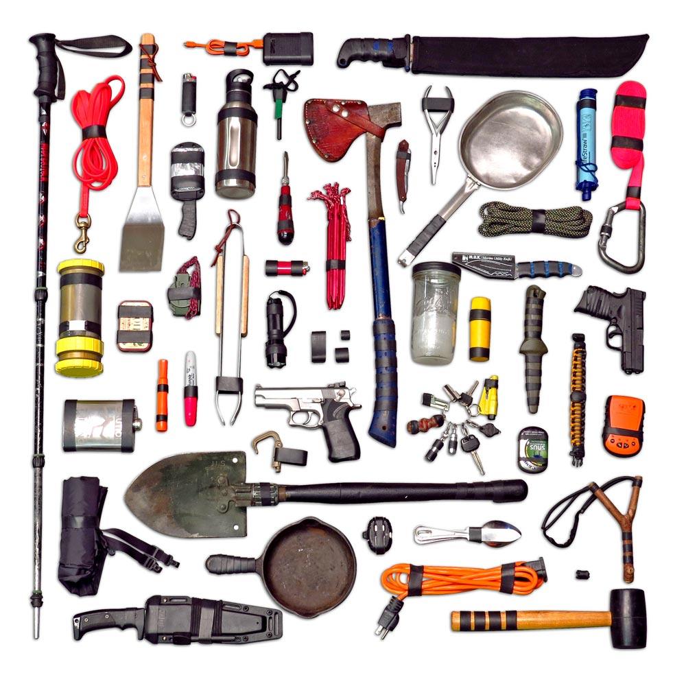 flay lay of tools including shovels, knives, axes, and rope that have ranger bands added to them